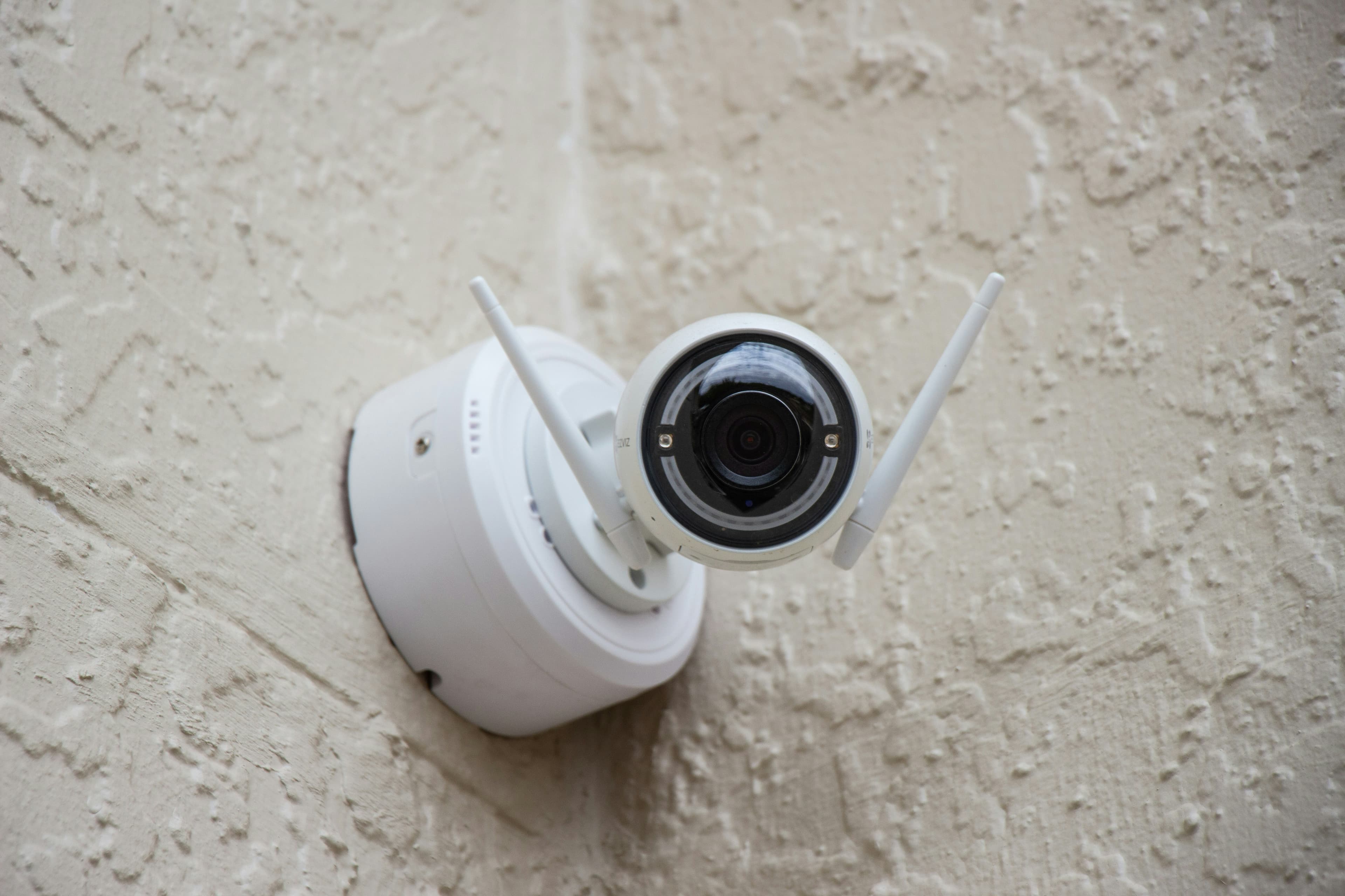 Caméra de vidéosurveillance fixée sur un mur blanc